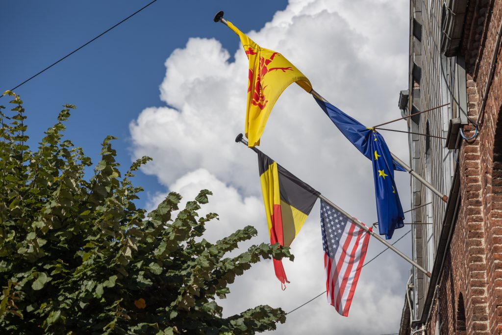 Drapeaux sur la façade de l'administration communale : états-unien, belge, wallon et européen
